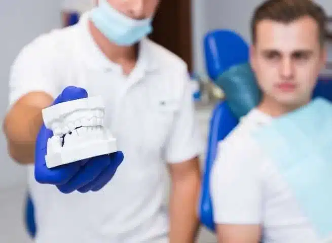 foto-odontologo-mostrando-muestra-de-protesisi-dental-nPXYIS