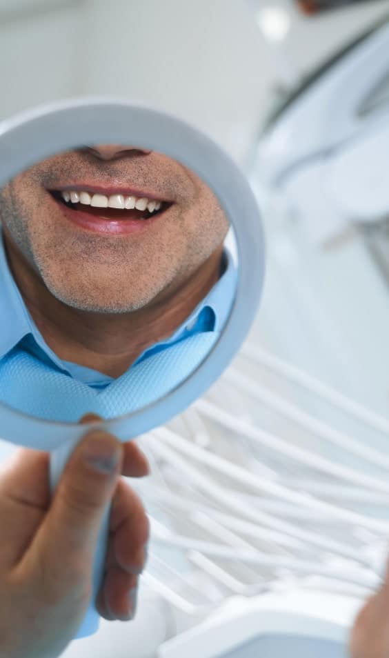 persona mirando sus dientes en un espejo